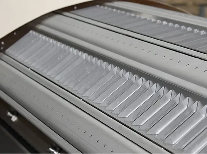 Close-up of metallic panels with evenly spaced ridges and perforations